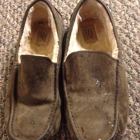 A pair of dirty stained suede slippers